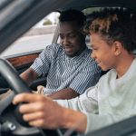 Man in White and Black Striped Dress Shirt Driving Car