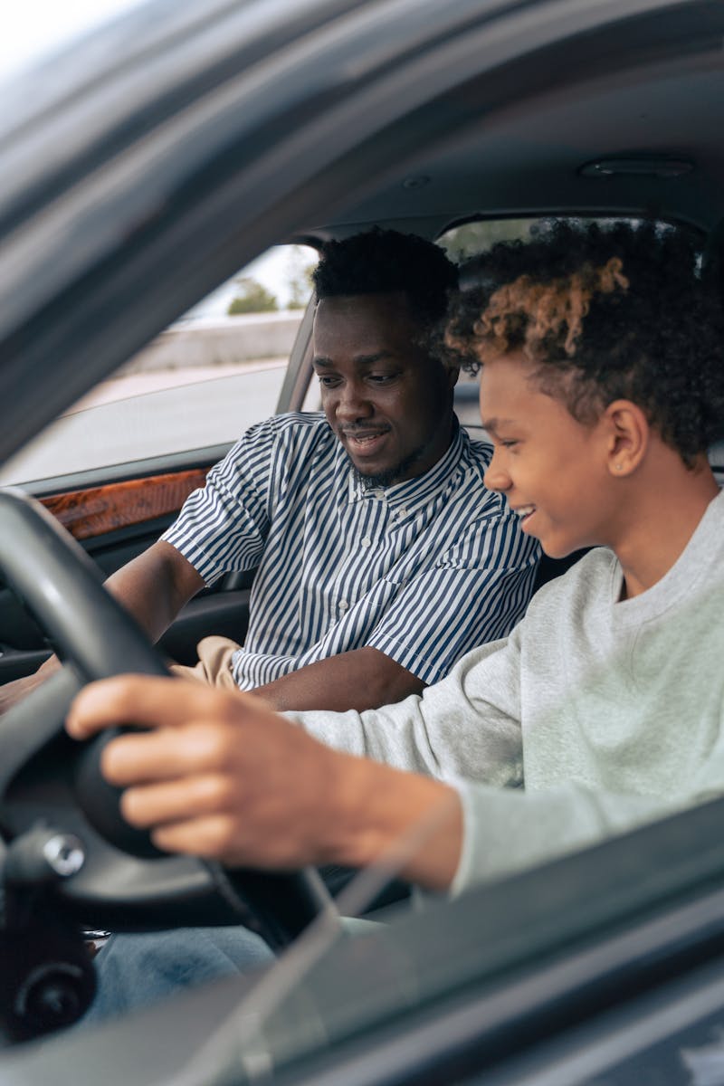 Man in White and Black Striped Dress Shirt Driving Car