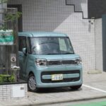 a small blue van parked in front of a building