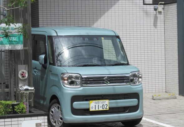 a small blue van parked in front of a building